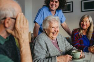Older woman enjoying coffee with loved ones while staying independent at home